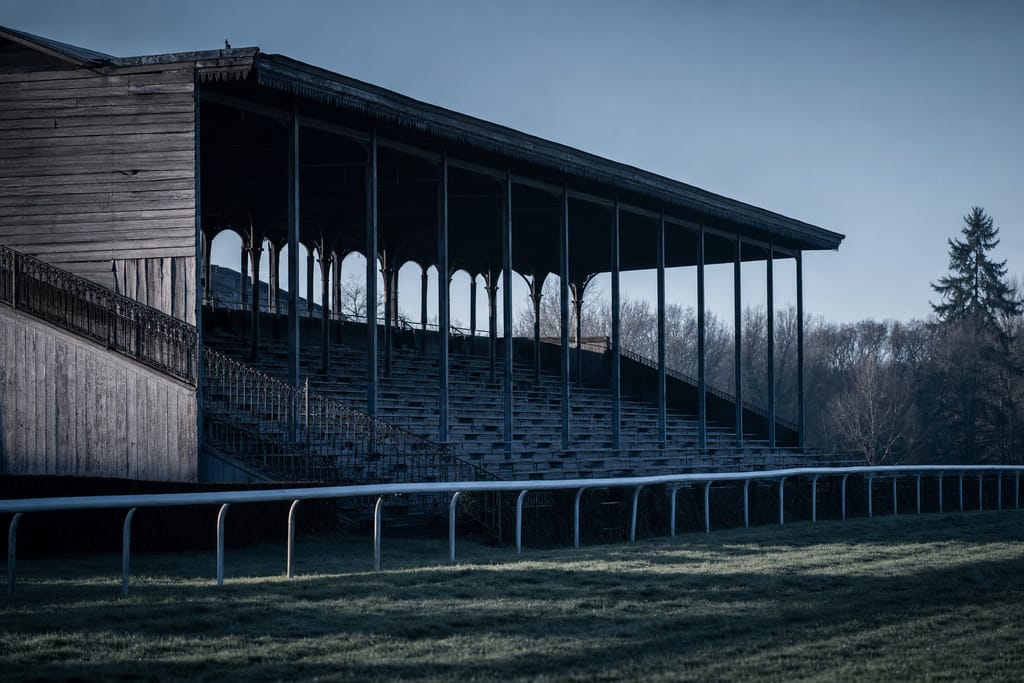 Leere hölzerne Tribüne einer ländlichen Grasrennbahn, verwittertes Holz und Eisengeländer
